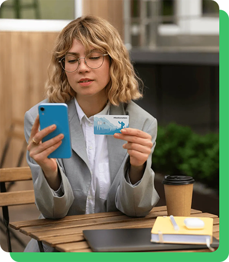 Image of woman looking at her phone holding her Motivosity Thanks Matters card